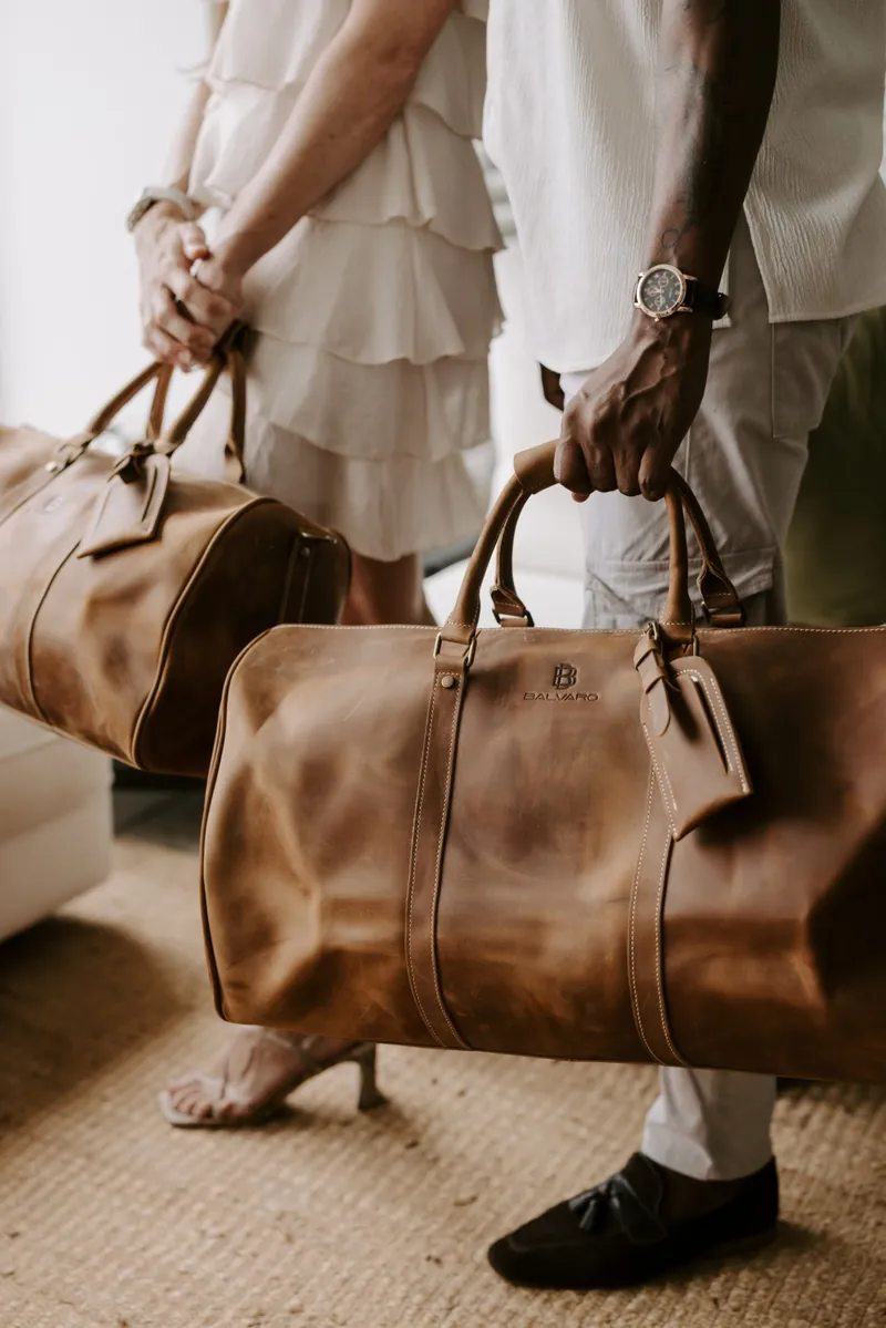 Close-up of a Balvaro leather duffel bag with the embossed Balvaro logo and a leather luggage tag