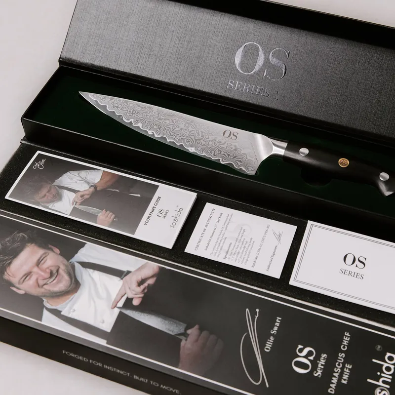 The Soshida OS Series Damascus chef's knife in its presentation box, with the Chef Ollie knife guide and certificate of authenticity