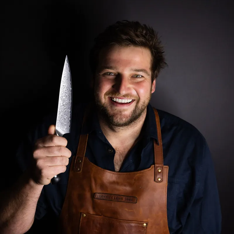 Chef Ollie Swart holding a Soshida OS Series Damascus chef's knife